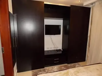 a black cabinet with a mirror in a bedroom at Sea View Duplex Villa in Hurghada