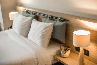 a bed with white pillows and a lamp in a room at Redcon Suites in Hurghada