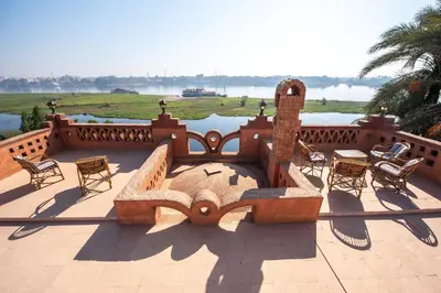 a patio with chairs and a fountain with a view of the water at villa al diwan luxor in Luxor