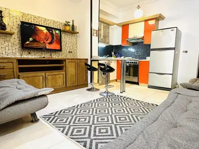 a kitchen with a refrigerator and a tv on a wall at Diamond Arabia with Wi Fi in Hurghada