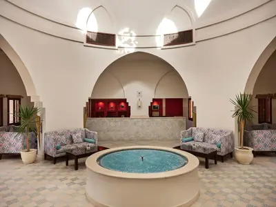 a lobby with a large pool in the middle of a building at Mosaique Hotel El Gouna in Hurghada