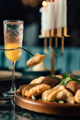 a table with a plate of food and a glass of wine at Mosaique Hotel El Gouna in Hurghada