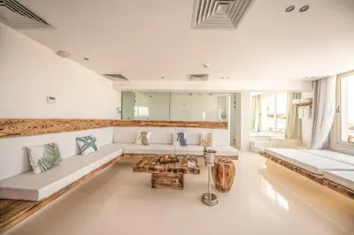 a living room with white couches and a table at Meraki Resort - Adults Only in Hurghada