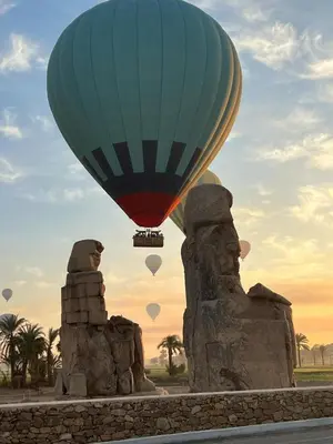 a hot air balloon flying over a statue at House of Dreams apartments Luxor in Luxor