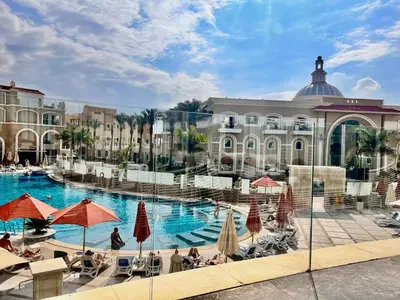 a large swimming pool with umbrellas and people sitting around it at KaiSol Romance Resort Sahl Hasheesh - Adults Only in Hurghada