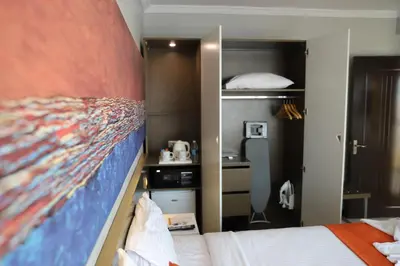 a bedroom with a bed with a large painting on the wall at Aswan Plaza Hotel in Aswan