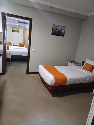 a bedroom with two beds and a large mirror at Aswan Plaza Hotel in Aswan