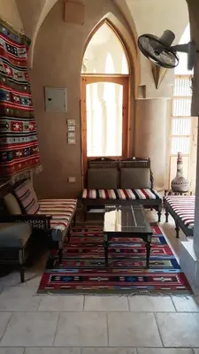 a living room with couches and a table and a window at Embrace Hotel in Luxor