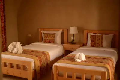 a hotel room with two beds with towels on them at Embrace Hotel in Luxor