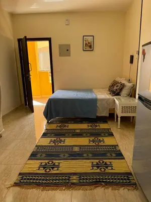 a bedroom with a bed and a rug on the floor at Cozy little studio near Kite station. in Hurghada