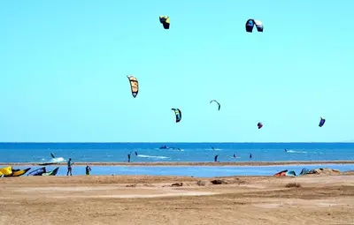 a group of people flying kites on the beach at Cozy little studio near Kite station. in Hurghada
