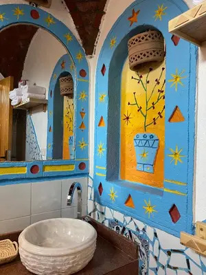 a bathroom with a blue and yellow wall with a sink at Kato Dool Wellness Resort in Aswan