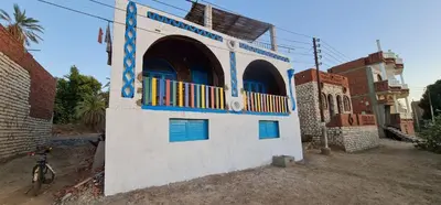 a building with blue windows and a bike in front of it at Meshra Katto in Aswan