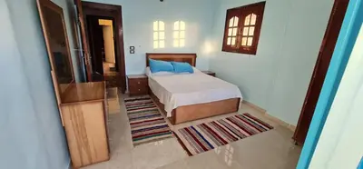 a bedroom with a bed with blue pillows on it at Meshra Katto in Aswan