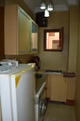 a small kitchen with a sink and a refrigerator at absolute sea view flatS in Hurghada