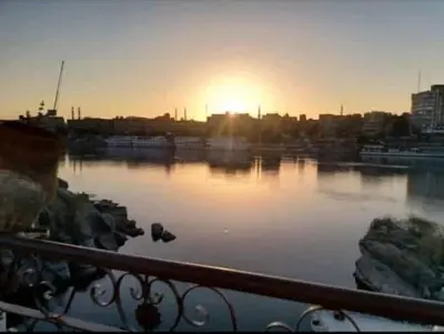 a sunset over a body of water with the sun setting at El-amin Guest House in Aswan
