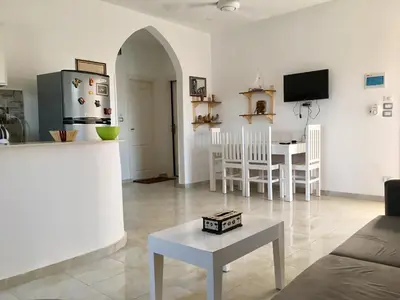 a living room with a refrigerator and a table at Luxor VIP Apartments in Luxor