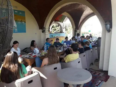 a group of people sitting at tables in a restaurant at El Prince Guesthouse in Aswan