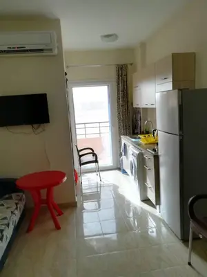 a kitchen with a red table and a refrigerator at Tiba Resort AA in Hurghada