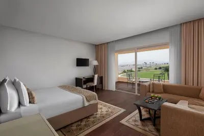 a bedroom with a bed and a living room at Steigenberger Makadi - Adults Friendly 16 Years Plus in Hurghada