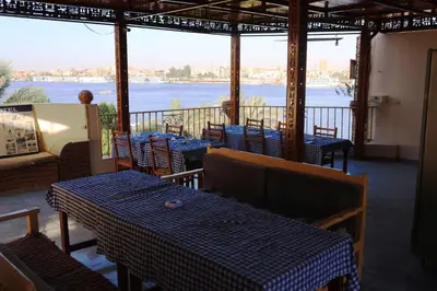 a restaurant with tables and a view of the water at Spring Hotel Luxor in Luxor