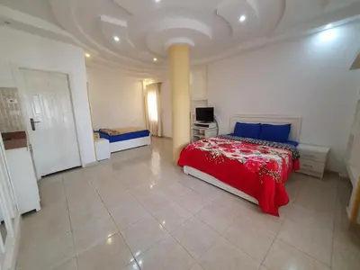 a bedroom with a red bed in a white room at Spring Hotel Luxor in Luxor