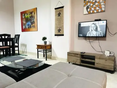 a living room with a couch and a tv on the wall at Safari Home with Wi Fi Hurghada center in Hurghada