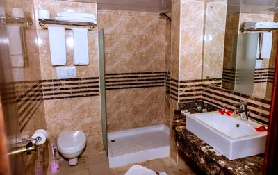 a bathroom with a sink and a toilet and a shower at Golden Beach Resort in Hurghada
