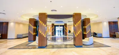 a lobby of a hotel with columns and a staircase at Golden Beach Resort in Hurghada