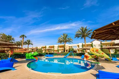 a swimming pool at a resort with a slide at Golden Beach Resort in Hurghada