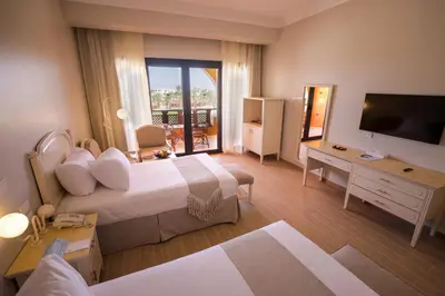 a hotel room with two beds and a television at Calimera Blend Paradise in Hurghada