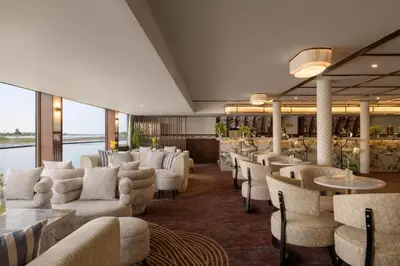 a restaurant with white chairs and tables and windows at Tamr Nile Cruise - 04 Nights Every Monday from Luxor - 03 Nights Every Friday from Aswan in Luxor