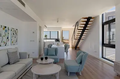 a living room with a couch and chairs and a staircase at VESTA - Soma Bay Residence in Hurghada