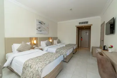 a hotel room with two beds and a television at Palm Beach Resort Families and Couples only in Hurghada