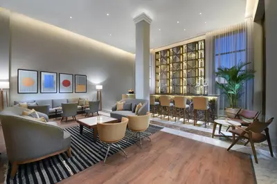 a lobby with couches and chairs and a large window at JAZ Elite Casa Del Mar Beach in Hurghada
