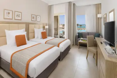 a hotel room with two beds and a television at JAZ Elite Casa Del Mar Beach in Hurghada