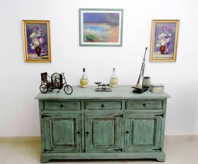 a green wooden dresser in a room with paintings on the wall at Aprtment at Abu Tig Marina - MP6 in Hurghada