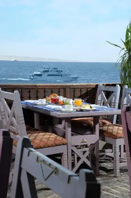 a table with food and a cruise ship in the ocean at Arabella Azur Resort in Hurghada