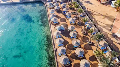 an overhead view of a swimming pool with chairs and umbrellas at Bel Air Azur Resort (Adults Only) in Hurghada