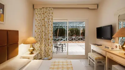 a hotel room with a bed and a sliding glass door at Giftun Azur Resort in Hurghada