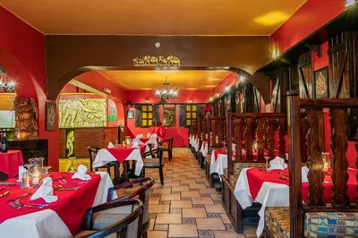 a restaurant with tables with red table cloths at Arabia Azur Resort in Hurghada