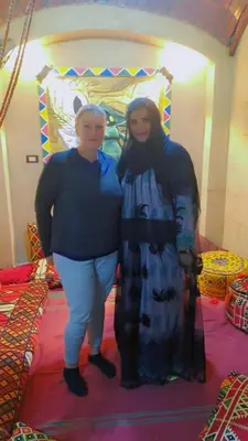 two women are standing next to a bed at Queen House in Aswan