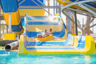 two people on a water slide at a water park at Blend Club Aqua Resort in Hurghada