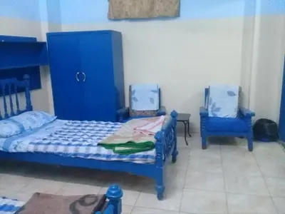 a bedroom with a blue bed and two blue chairs at Oasis hotel in Luxor