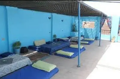 a room with blue pillows and a group of beds at Oasis hotel in Luxor