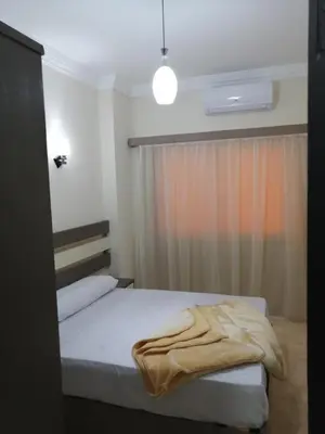 a bedroom with a bed with a blanket on it at Nour Plaza Hurghada النور بلازا الغردقة in Hurghada