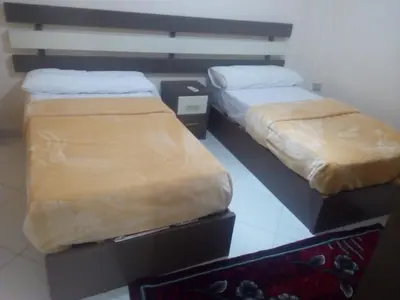 two beds sitting next to each other in a room at Nour Plaza Hurghada النور بلازا الغردقة in Hurghada