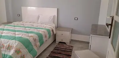 a bedroom with a bed with a green and white comforter at Villa Dream in Luxor