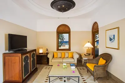a living room with a couch and a tv at The Oberoi Beach Resort, Sahl Hasheesh in Hurghada