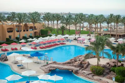 an aerial view of a resort swimming pool with umbrellas at Stella Beach Resort & Spa, Makadi Bay in Hurghada